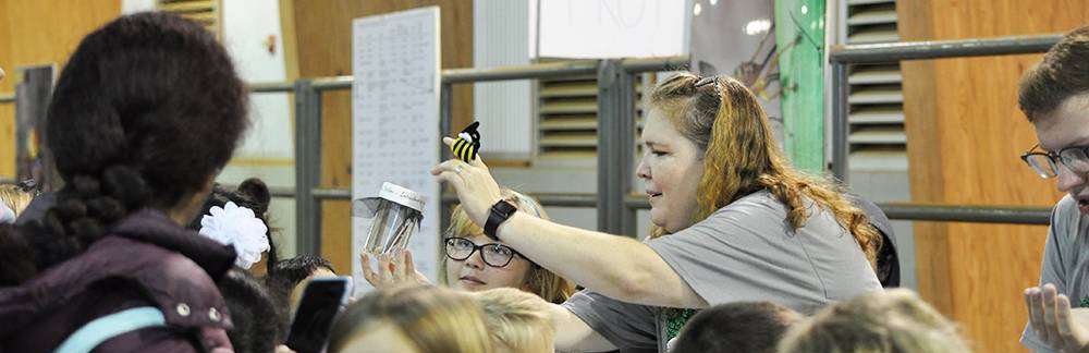 Woman showing a small child an insect container at the 2018 Insect Festival of Arkansas.